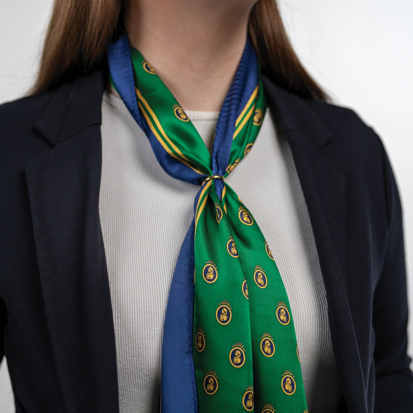 Woman wearing a green and blue patterned scarf with a white background