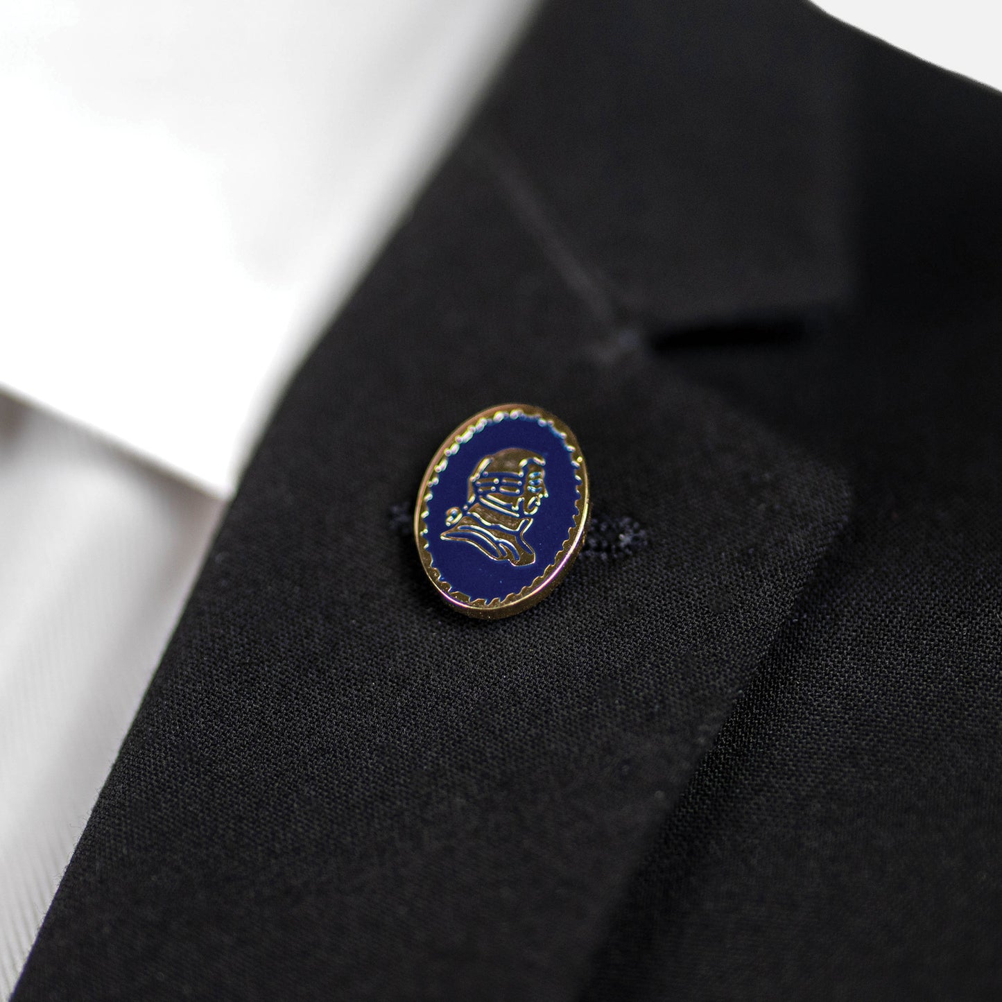 Blue and gold lapel pin on a black suit jacket.
