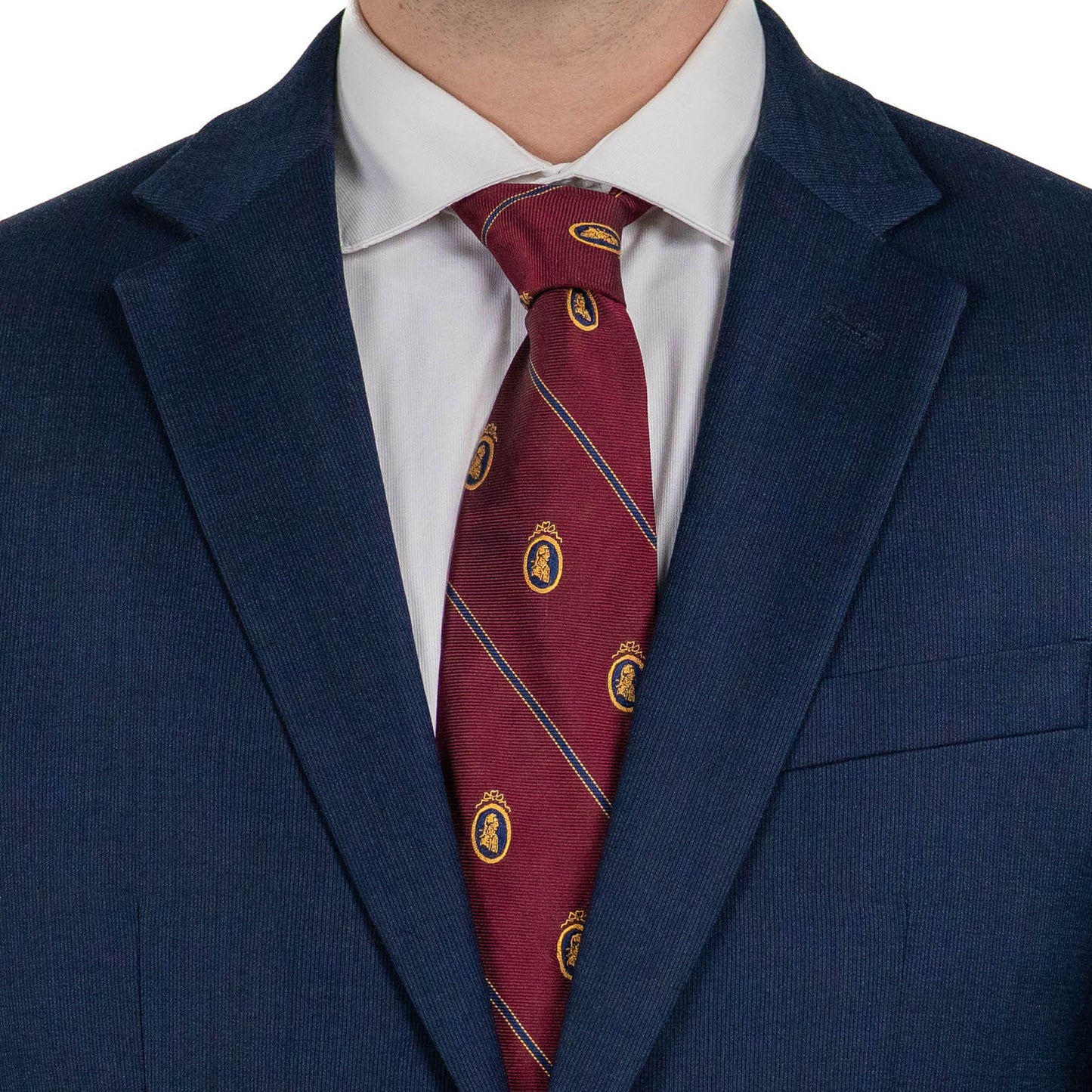 A close-up of a person wearing a navy suit jacket and white dress shirt, with a burgundy tie featuring diagonal stripes and small gold crest patterns.