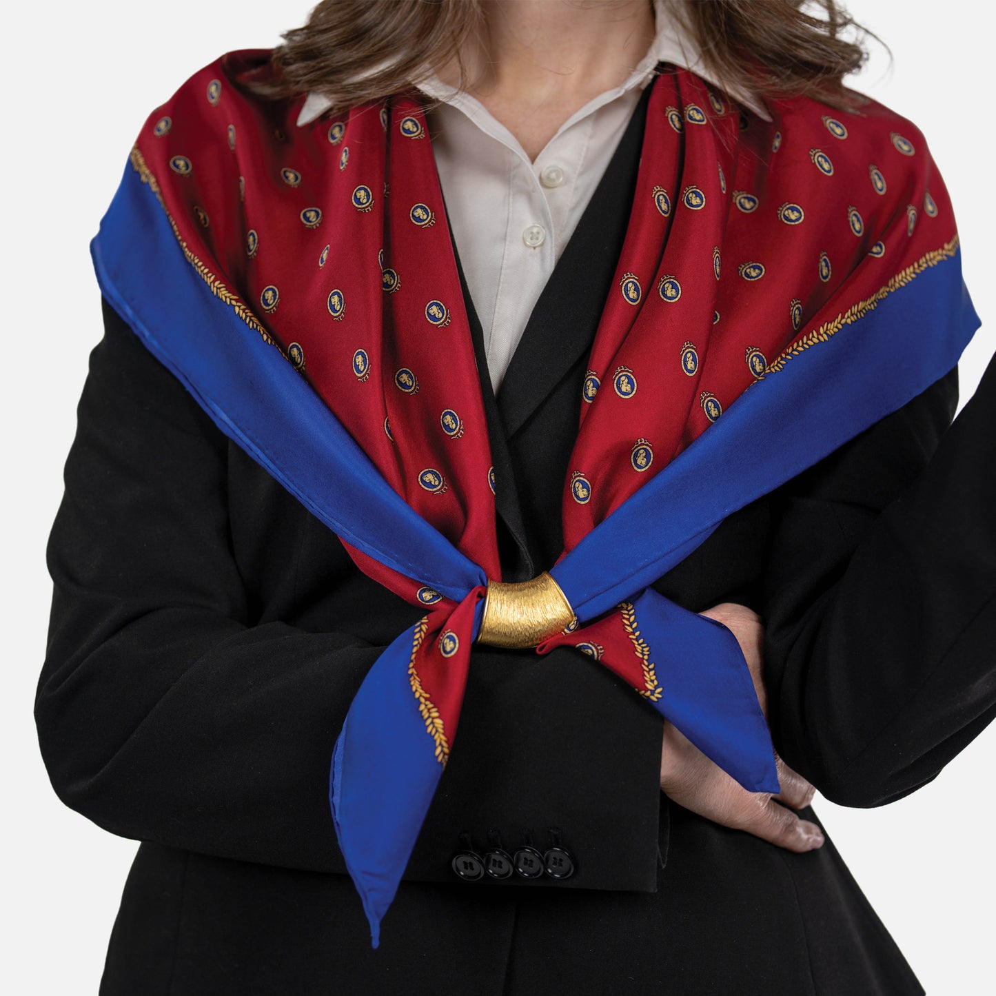 Woman wearing a red and blue patterned scarf with a gold accent on a white background